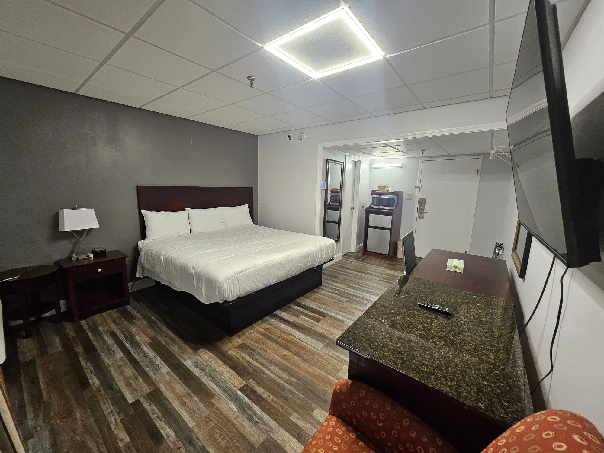 Saffron Inn king balcony room — alternate angle showing the king bed, work desk, microwave and mini-fridge alcove by the door